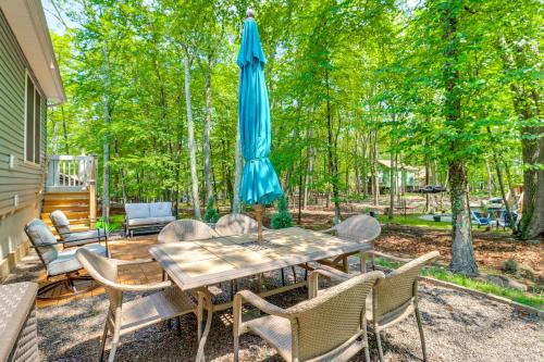 a patio with a table with an umbrella and chairs at 7 Mi to Camelback Mtn Chic Penn Estates Home in East Stroudsburg