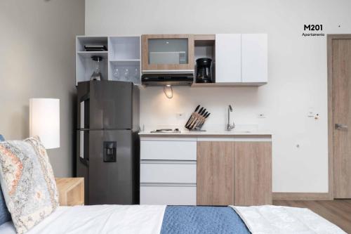 a small kitchen with a refrigerator and a sink at Magusan Holiday Rentals in Cali