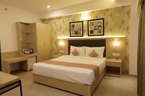 a bedroom with a large bed in a room at Hotel Ramida Suites At Delhi Airport in Jāmb