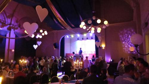 a crowd of people in a room with a man on a stage at Hotel Elefant in Schwerin