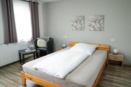 a bedroom with a bed and a chair at Gasthof Wolfs Stuben in Reichenbach an der Fils