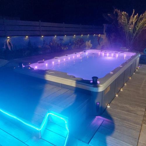 - une piscine éclairée dans un jardin la nuit dans l'établissement Au gué du bois, à Neuville-du-Poitou