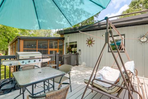 a patio with a grill and chairs and an umbrella at Walk to Lake Fayetteville Family Retreat with Deck in Springdale