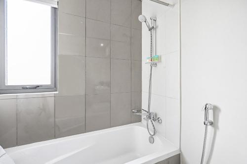 a bathroom with a shower and a white bath tub at Damac Hills 2 Poolside - The Larger 3 BR Villa in Dubai