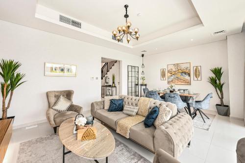 a living room with a couch and a table at Damac Hills 2 Poolside - The Larger 3 BR Villa in Dubai