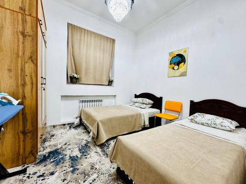 a room with two beds and a window at Komolon in Tashkent
