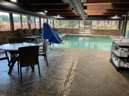 a swimming pool with tables and chairs in a restaurant at Comfort Inn & Suites Near Lake Guntersville in Scottsboro