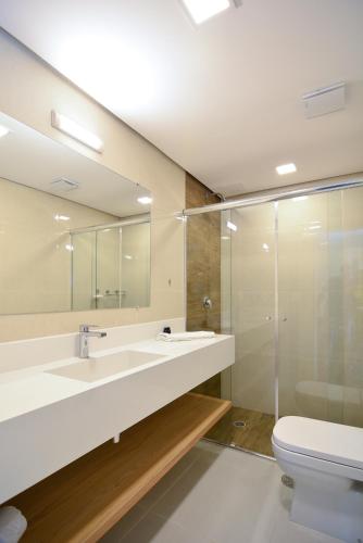 a bathroom with a sink and a toilet and a mirror at Flat Fortune Jardins in Sao Paulo
