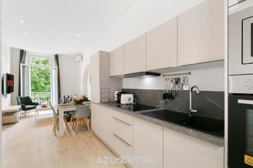La cuisine est équipée de placards blancs et d'un évier noir. dans l'établissement Azurenting - Harbor View - Amazing Stay 1, à Vallauris