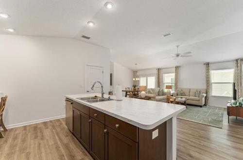 a kitchen with a sink and a living room at Designers 3BR in The Villages With Four Seaters Golfcart King Bed in The Villages