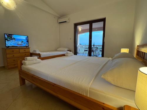a bedroom with a large bed and a television at Apartments Bernarda 2 in Nin