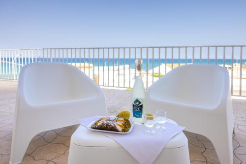 due sedie bianche con un piatto di cibo e dei bicchieri di Casa Liliana 1 a Cava dʼAliga