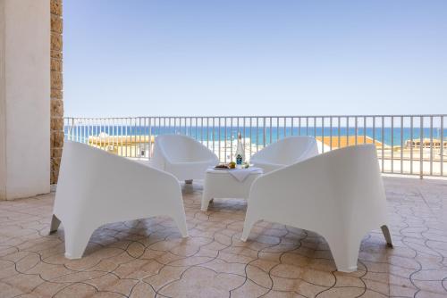 2 sedie bianche e un tavolo sul balcone di Casa Liliana 1 a Cava dʼAliga