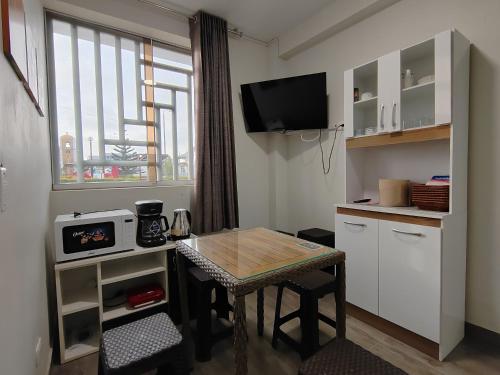 Una pequeña cocina con una mesa y una ventana. en Plaza Chicama, en Puerto Chicama