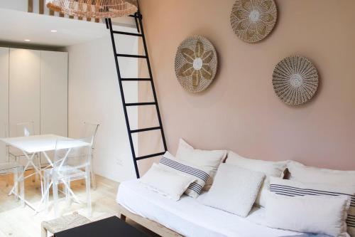 sala de estar con sofá blanco y escalera en Charming house in Montreuil with terrace, en Montreuil