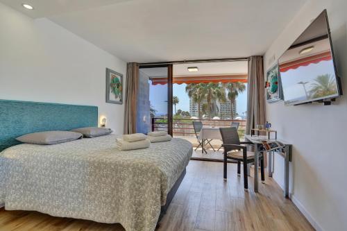 Un dormitorio con una cama y un balcón. en Sunset Tenerife, en Playa de las Américas