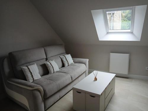 a living room with a couch and a table at Studio de la Maison Bleue in Lanvallay