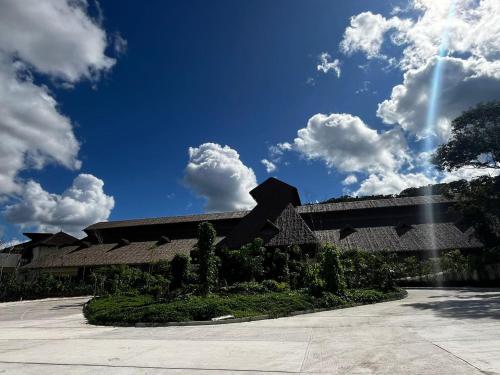 a building with a blue sky and clouds at Hotel Mundo Maya Calakmul in Xpujil