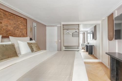une chambre avec un grand lit blanc dans une pièce dans l'établissement Luxury Living in Paris 1er - Palais Royal, Victoires-louvre, à Paris
