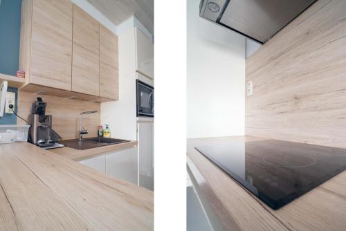 a kitchen with wooden cabinets and a counter top at Studiodevos in Middelkerke