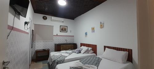a room with two beds in a room at Hospedagem da Néli in Aparecida