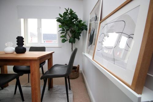 a dining room with a wooden table and black chairs at Alicia's House by Tŷ SA in Newport