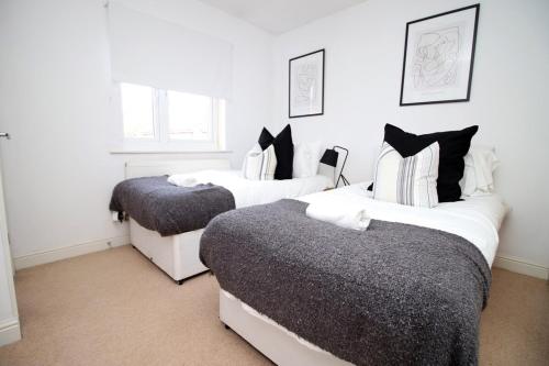 a bedroom with two beds with black and white at Alicia's House by Tŷ SA in Newport