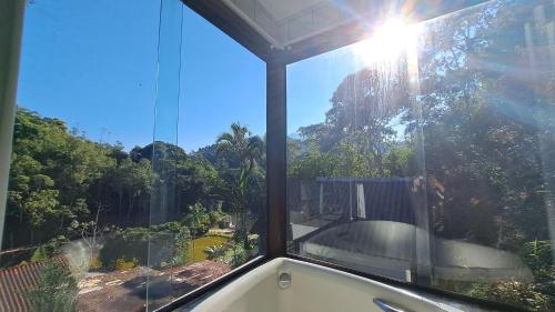 a view of a bath tub in a room with a window at Pousada Valle dos Pássaros in Penedo