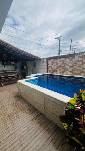 a large swimming pool on a wooden deck with at Bahia Bella Casa 01 in Santa Cruz Cabrália