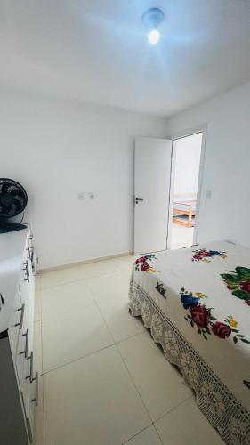 a bedroom with a bed in a white room at Bahia Bella Casa 01 in Santa Cruz Cabrália