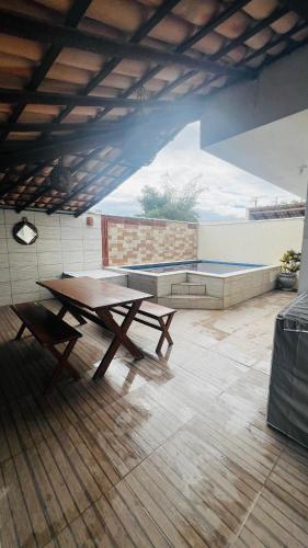 a picnic table and a bench in a room at Bahia Bella Casa 01 in Santa Cruz Cabrália