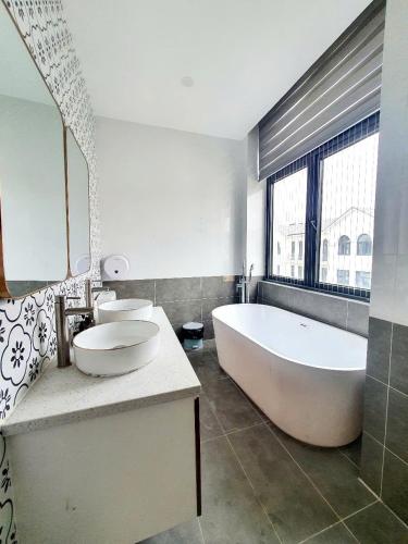 a large bathroom with a large tub and a sink at AnDi's Homestay in Gò Công
