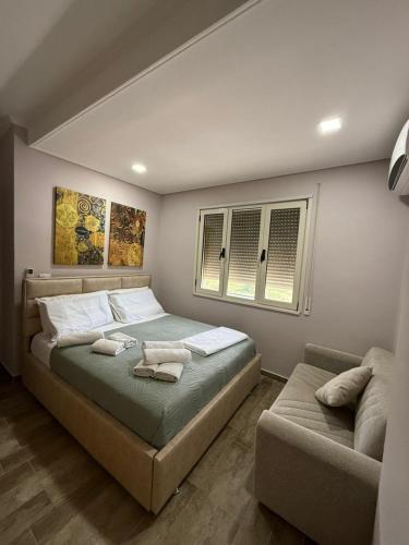 a bedroom with a large bed and a couch at Coco Apartments in Vlorë
