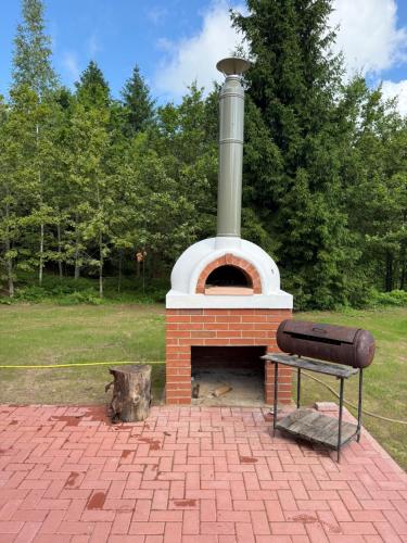 a brick oven with a bench in front of it at Kaimo turizmo sodyba „Šerno slėnis“ in Vėdariai