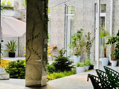 a pillar in a courtyard with plants at Komolon in Tashkent