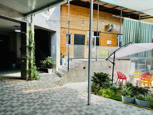 a building with a patio with chairs and an umbrella at Komolon in Tashkent