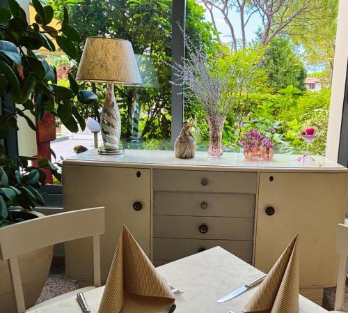 a dresser with a lamp and two cats sitting on it at Hotel Alfieri in Sirmione