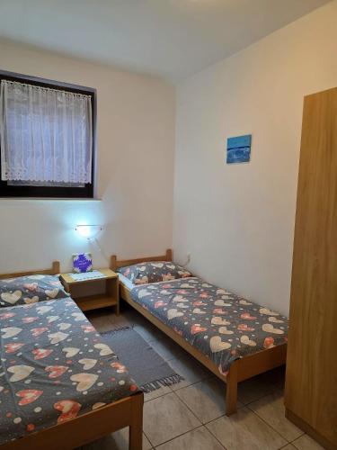 a room with two beds and a window at Apartmani Hotko 1 in Sveti Juraj