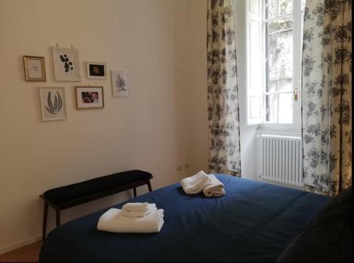 una camera da letto con asciugamani su un letto con finestra di Appartamento accogliente - zona Salario Nomentano - WiFi, aria condizionata a Roma