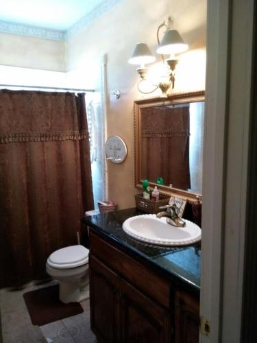 a bathroom with a sink and a toilet and a mirror at Klauzz in Bay City