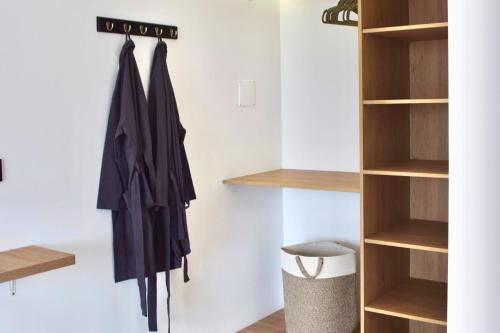 a walk in closet with wooden shelving at Tiny House con Piscina Privada, Jacuzzi, Parrilla y Starlink in Punta Negra