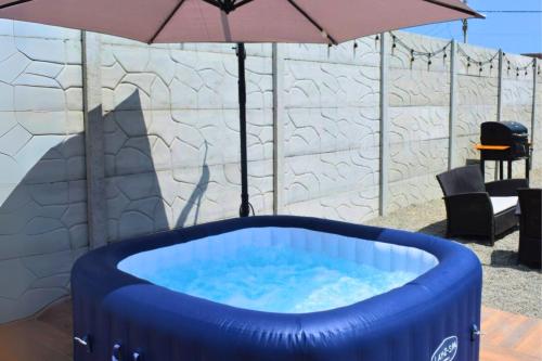 a large blue tub sitting under an umbrella at Tiny House con Piscina Privada, Jacuzzi, Parrilla y Starlink in Punta Negra