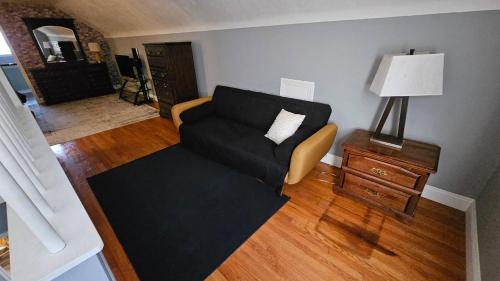 a living room with a black couch and a lamp at Urban Farmer House in Millman