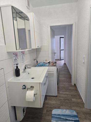 a white bathroom with a sink and a mirror at Beethoven Apartments in Solingen