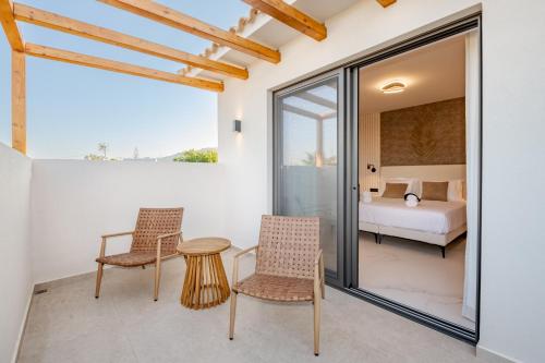 a bedroom with a bed and a table and chairs at Anar Luxury Villas in Kalamaki