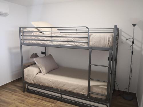 a metal bunk bed with a pillow on the bottom bunk at Blue Ocean Apartments in Benalmádena