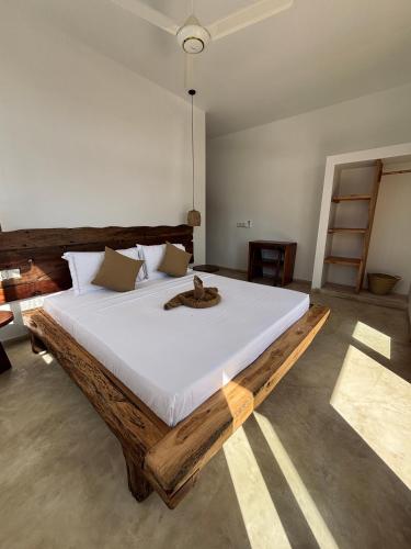 a bedroom with a large bed with a cat on it at Tumbili Hotel Boutique in Paje