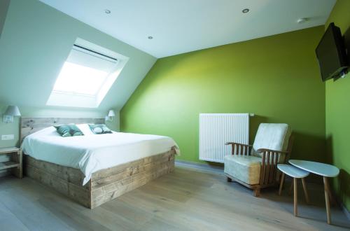 a bedroom with a bed and a tv and a chair at Kokkelikoo in Blankenberge