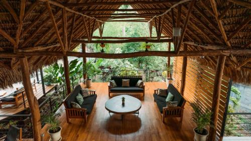an open living room with a table and chairs at TreeCasa Hotel & Resort Nicaragua in San Juan del Sur