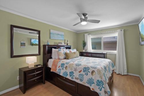 Un dormitorio con una cama y un espejo y una ventana. en Coastal Breeze Siesta – Entire 4-Unit Complex with Dock, en Sarasota